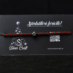 Charm steluță mică din argint 925, lucrat manual, pe șnur roșu și verde, așezat pe carton festiv tematic de Crăciun – bijuterie delicată pentru cadouri de iarnă.