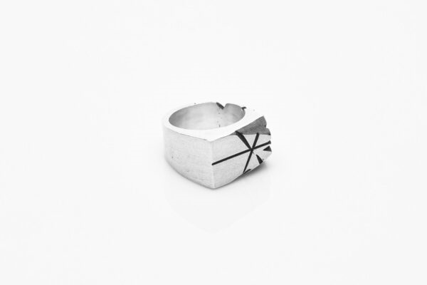 Inel masculin din argint 925, fotografiat dintr-un unghi creativ – design modernist și finisaj patinat.